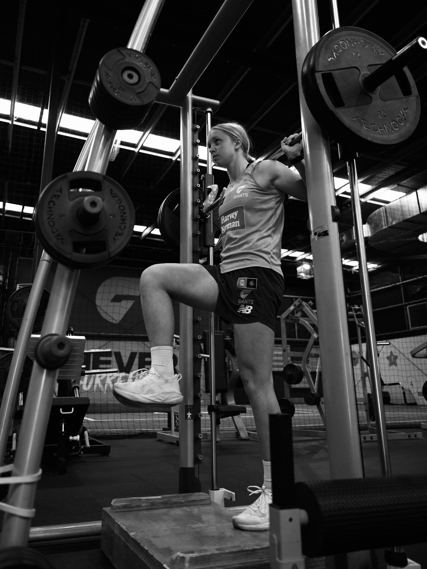 Sophia lifting in the gym — black and white.